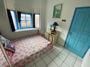 SentoolSinggah Macanan的一间卧室配有一张床和一个蓝色的门