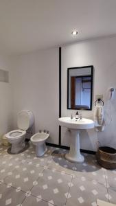查斯科穆斯La Botica de 1852 Hotel的浴室设有2个卫生间、水槽和镜子