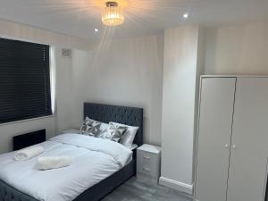 雷纳姆Luxury 3 bedroom house Rainham Essex - Free parking and Wifi的一间卧室配有一张大床和一个吊灯。