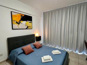 LivadhiaFatCow Seaside Suites的一间卧室配有一张床,上面有两条毛巾