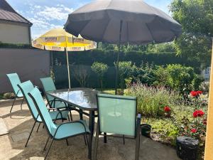 蒙蒂尼亚克Au pied de Lascaux的庭院内桌椅和遮阳伞