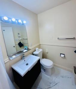 洛杉矶Foghorn Harbor Inn的一间带卫生间、水槽和镜子的浴室