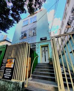 贝洛奥里藏特Cool Living Hostel - Praça da Liberdade的蓝色的建筑,楼梯通往门