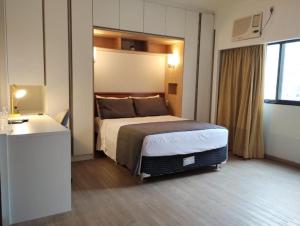 圣保罗UH 1002 Flat Live Logde Vila Mariana Pq Ibirapuera的配有一张床和一张书桌的酒店客房