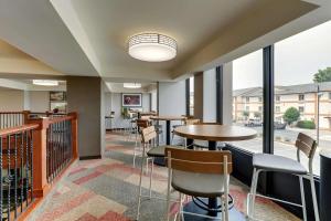 伯明翰Drury Inn & Suites Birmingham Lakeshore Drive的餐厅设有桌椅和窗户。