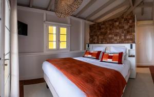 莱特鲁瓦西莱套房别墅酒店的一间卧室配有一张带橙色和白色枕头的大床