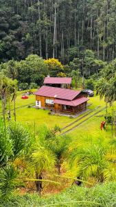 Muniz FreireBangalô-Nosso Escritorio-Hospedagem Rural的田野上红色屋顶的房子