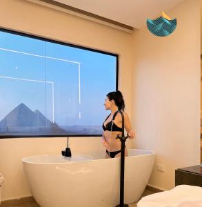 开罗Crowne Pyramids view inn的站在浴室浴缸中的女人