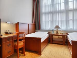 汉堡丹姆特帕拉兹贝尔莫酒店的一间卧室设有两张床、一张桌子和一个窗口。