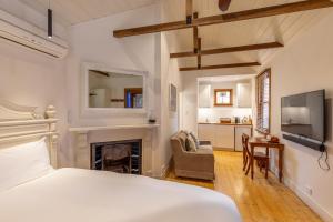 瑟尔Bon Accord Luxury Accommodation的一间白色卧室,配有一张床和一个壁炉