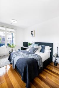 悉尼Not your usual studio apartment的一间卧室配有一张带蓝色枕头的大床