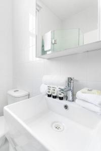 悉尼Not your usual studio apartment的白色的浴室设有水槽和镜子