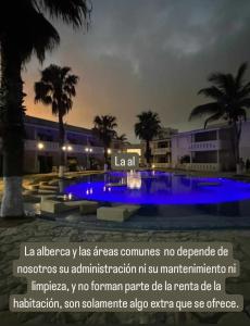 马德罗城Carasol Villas y Suites Privadas的建筑前的蓝色灯光游泳池