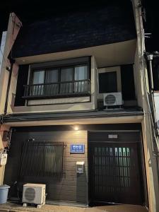 京都明和荘Mei Wa Inn的一座带门、阳台和门的建筑