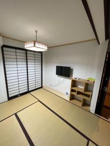京都明和荘Mei Wa Inn的一间空房间,配有电视和书桌