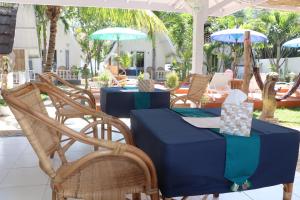 吉利阿尔New Balengkudua Hotel的一张桌子和椅子,配有蓝色的桌子和遮阳伞