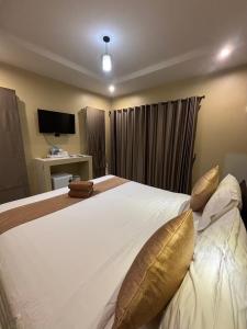 高兰Serene Lanta Resort的卧室配有带金色枕头的大型白色床