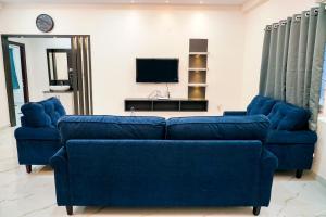 海得拉巴N Cube Serviced Apartments的客厅配有2张蓝色沙发和电视