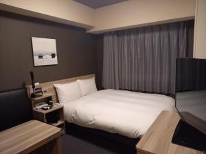 ChuoHotel Route-Inn Yamanashi Chuo的酒店客房,配有床和电视