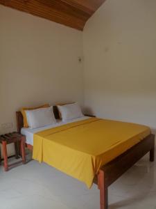 代尼耶耶Serenity Sinharaja的一间卧室配有一张黄色毯子床