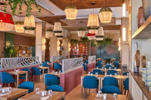 勒莫尔尼Riu Turquoise - All Inclusive的一间配备有桌子和蓝色椅子的用餐室
