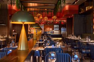 勒莫尔尼Riu Turquoise - All Inclusive的一间设有蓝色桌椅和灯的餐厅