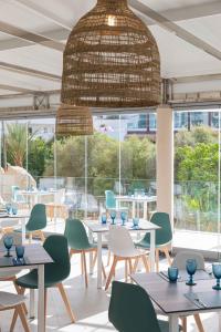 卡拉达沃MarSenses Natura Olea Hotel的餐厅设有桌椅和大窗户。