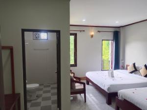 万荣Dokchampa Hotel的一间卧室配有一张床,浴室设有卫生间