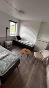 GratangenStorfossen Hostel的客房设有两张床、一张沙发和一张桌子。