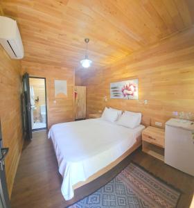 契拉勒巴拉卡住宿酒店的木制客房内的一间白色床卧室