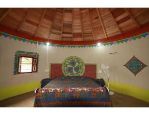 BherandiālaRann Chandni Resort, Kutch, Bhuj的一间卧室配有一张带彩色床罩的床