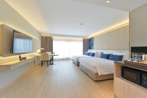 曼谷水门中心点酒店的酒店客房设有一张床、一张书桌和一台电视机。