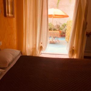圣雷莫阿菲塔卡梅塞勒涅旅馆的一间卧室配有一张床,窗户配有雨伞