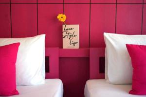 查汶LOVE beach club Koh Samui的配有粉红色墙壁和一张卡的客房内的两张床