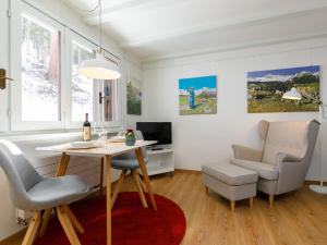 苏尔勒吉Apartment Residenza Chesa Margun 710-5 by Interhome的客厅配有桌椅和书桌。