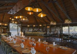 MababeHideaways Mogotlho Safari Lodge, Khwai River的大型用餐室配有长桌和吊灯