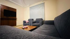 麦地那Basma Suites的客房设有床、沙发和电视。