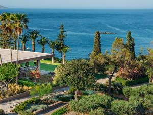 阿基欧斯尼古拉斯米诺斯宫套房酒店 - 仅限成人入住的享有花园的景色,背景是大海