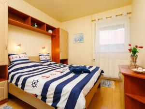 BadacsonyHoliday Home Toth - BAC109 by Interhome的一间卧室配有一张带蓝白条纹毯子的床