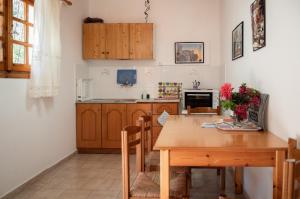 帕莱欧卡斯提撒尤利西斯公寓的一间带木桌的厨房和一间餐厅