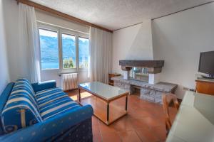 利莫内-苏尔加达玛格丽塔别墅酒店的客厅设有蓝色的沙发和壁炉