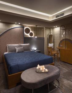 乐托卡亚CORYLUS Luxury Rooms & Suites的一间卧室配有一张蓝色的床和一张带蜡烛的桌子。