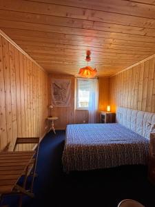 巴斯洛内特Chez LIZON的木制客房内的一间卧室,配有一张床