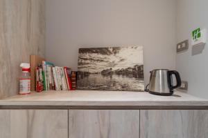 基隆安樓文旅Enzo House的一个带咖啡壶的架子和上面的书籍