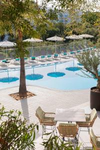 卡拉达沃MarSenses Natura Olea Hotel的一个带桌椅和遮阳伞的游泳池