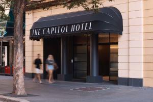 悉尼The Capitol Hotel Sydney的两个人在酒店前行走