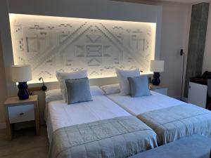托莱多德尔卡德纳尔庄园酒店的一间卧室配有两张带蓝色枕头的床