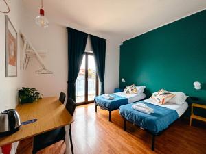 米兰Ostello Bello Milano Centrale的客房设有两张床、一张桌子和一张桌子。