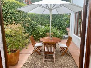 开普敦阿考恩楼旅馆的庭院内桌椅和遮阳伞