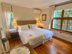 开普敦阿考恩楼旅馆的卧室配有白色的床和2扇窗户。